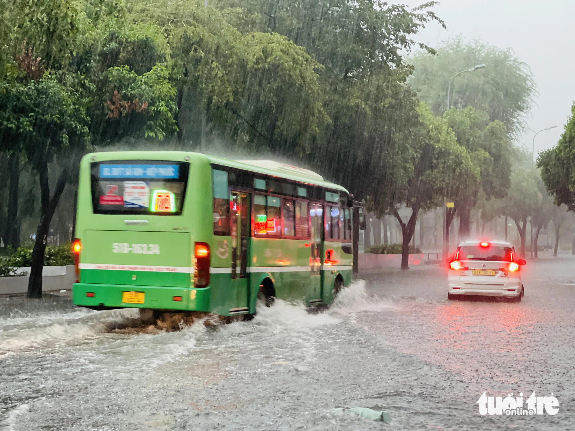 Chiều nay mưa lớn, TP.HCM, Bình Dương xuất hiện mưa đá- Ảnh 12. Xe buýt chạy qua tạo thành sóng nước trên đường Lê Lai, quận 1 - Ảnh: LÊ THÀNH HUY