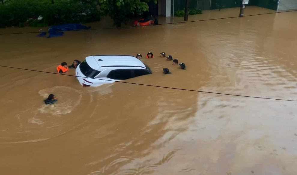 Lũ lớn trong đêm, thành phố Hà Giang ngập sâu, có nhà ngập tới nóc- Ảnh 7. Lực lượng chức năng đang di chuyển một ô tô ra khỏi khu vực ngập sâu ở khu vực chợ Phương Thiện - Ảnh: Nguyễn Cường