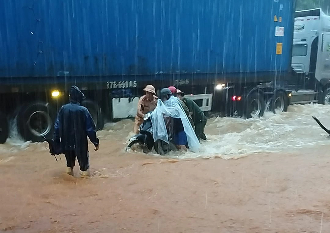 Hà Giang lại mưa lớn, nhiều nơi ngập úng- Ảnh 3. Lực lượng cảnh sát giao thông hỗ trợ người dân đi qua khu vực ngập sâu trên quốc lộ 2 đoạn qua huyện Vị Xuyên - Ảnh: N. HOÀN